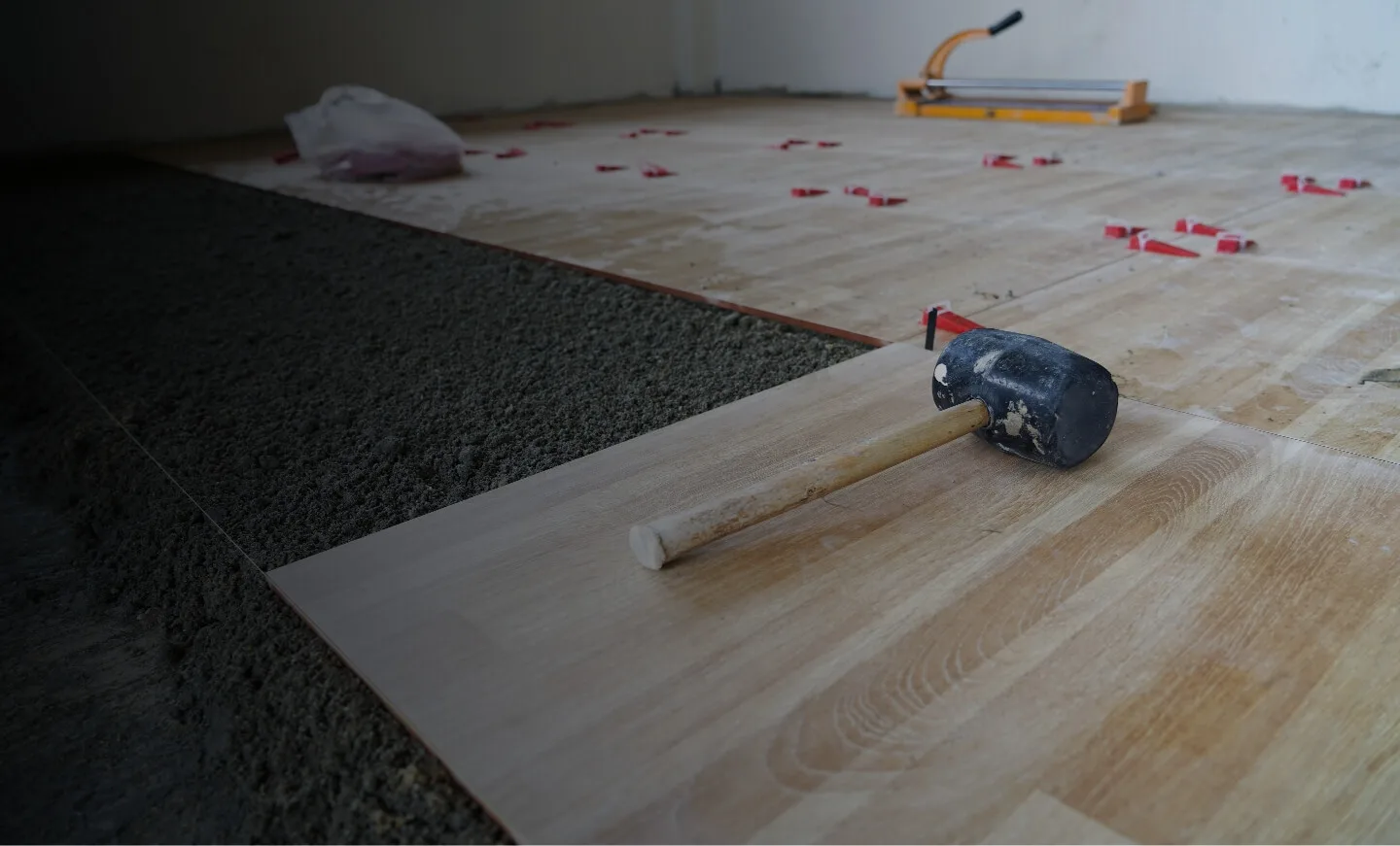 Verlegung von Laminatboden mit Werkzeug und Abstandshaltern im Raum