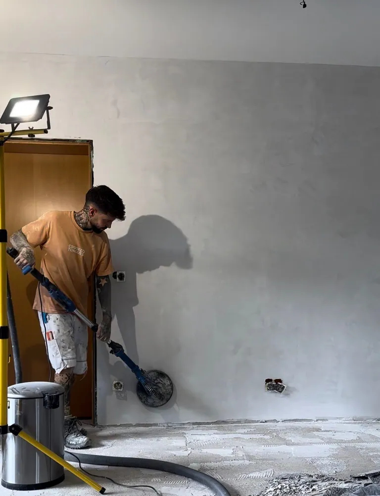 Maler aus dem MyWorker-Team schleift eine Wand für den perfekten Untergrund