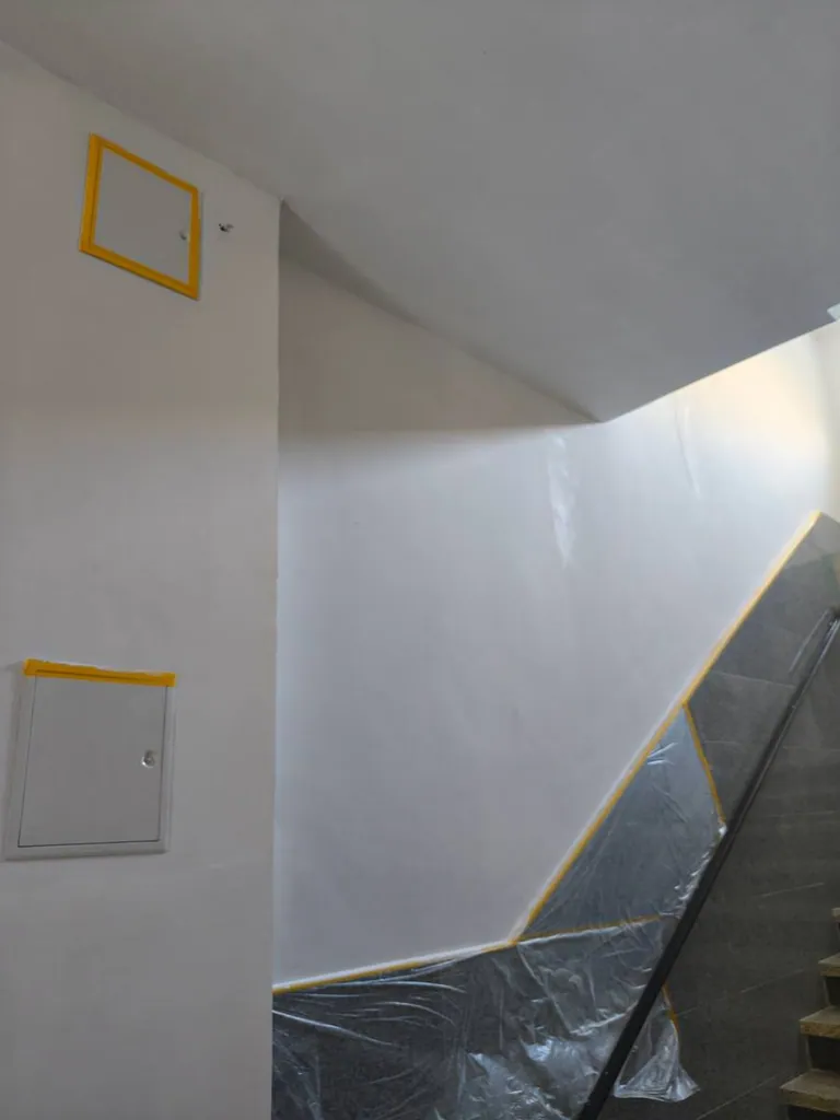 Frisch gestrichenes, sauber abgeklebtes Treppenhaus eines Gewerbeobjekts