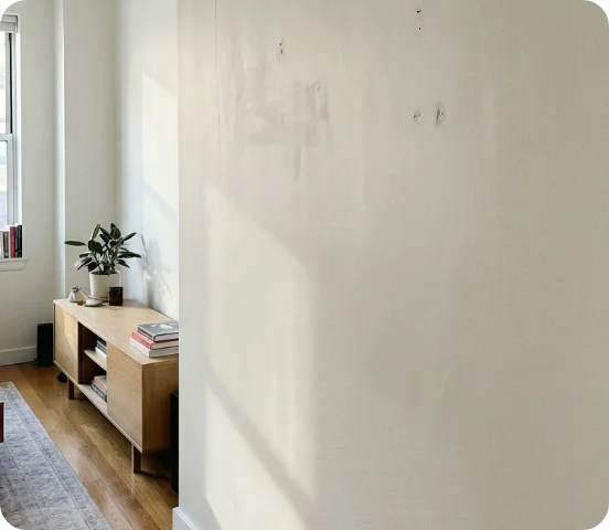 Wand vor Renovierung mit Löchern, Flecken und unebener Oberfläche im Wohnraum