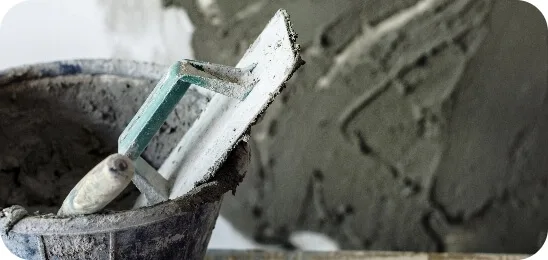 Kelle mit Putzmörtel beim Verputzen einer Wand im Innenbereich